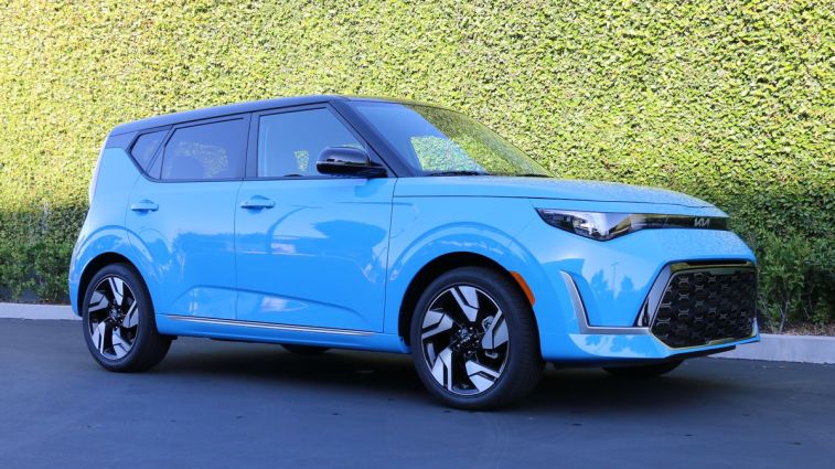 2024 Kia Soul GT Line in blue next to an ivy wall.