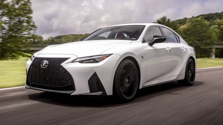 2024 Lexus IS 350 F Sport driving down a highway.
