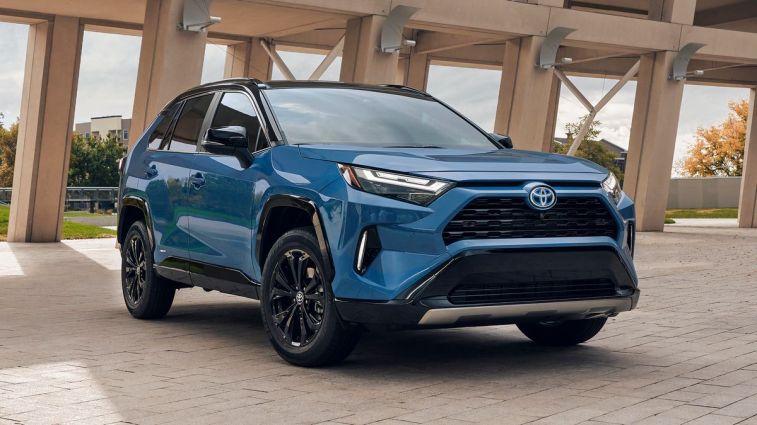 2024 Toyota RAV4 Hybrid XSE in blue near a bridge.