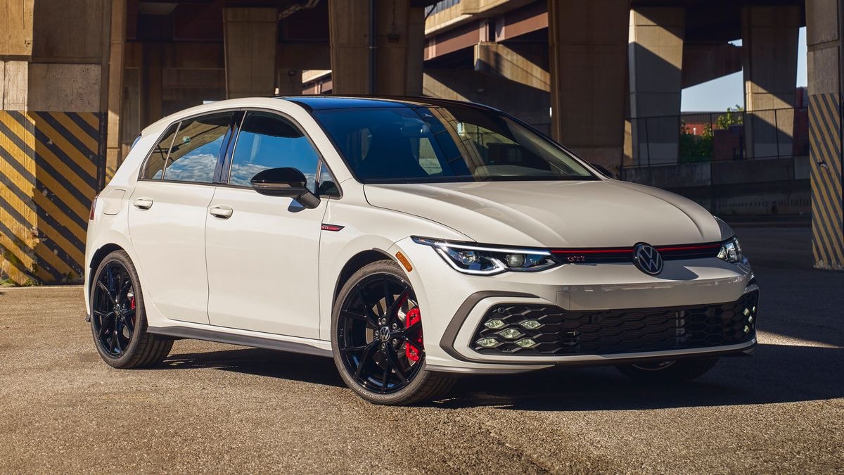 2024 Volkswagen Golf GTI in white under a freeway overpass.