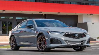 2024 Acura TLX Type S in Urban Grey Pearl near an office building.