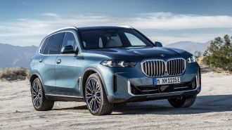 2024 BMW X5 in blue with mountains in the background.