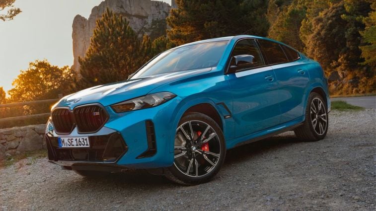2024 BMW X6 in blue with rock formations in the background.