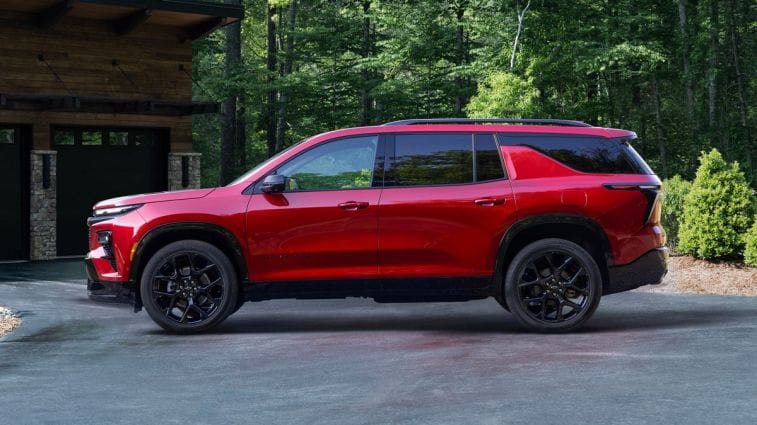 2024 Chevrolet Traverse RS في Tintcoat Radiant Red متوقفة في ممر.