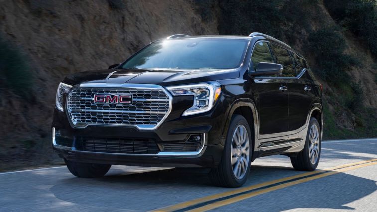 2024 GMC Terrain Denali in Ebony Twilight Metallic driving on the road.