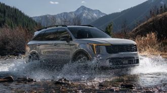 2024 Kia Sorento X-Pro driving through a stream.