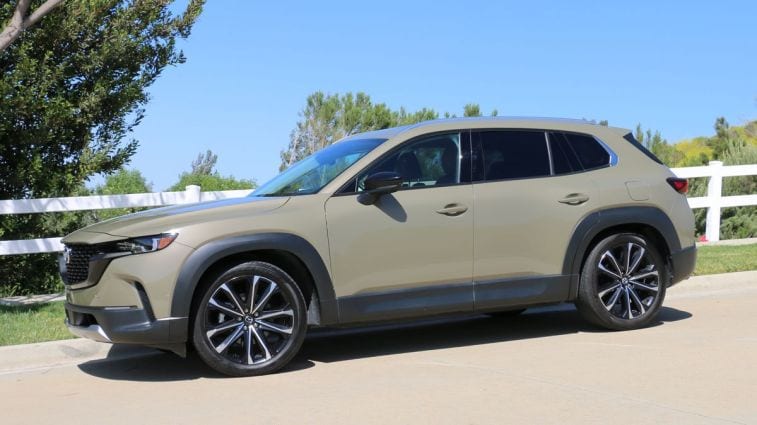 2024 Mazda CX-50 بجانب سياج أبيض.