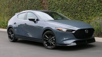 2024 Mazda3 2.5 Turbo Premium Plus in Polymetal Grey Metallic. near an ivy wall.