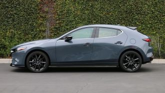 2024 Mazda3 2.5 Turbo Premium Plus in Polymetal Grey Metallic. near an ivy wall.