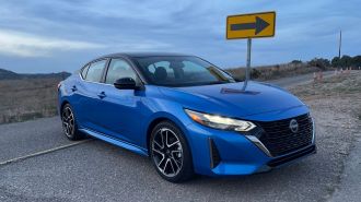 2024 Nissan Sentra SR in blue near a directional sign.