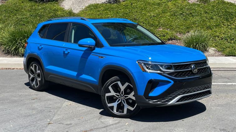 2024 Volkswagen Taos in blue with ivy in the background.