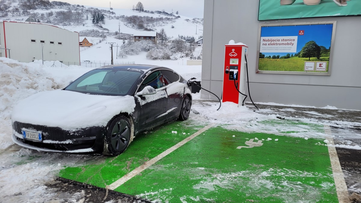 A Tesla Model 3 charging in the snow