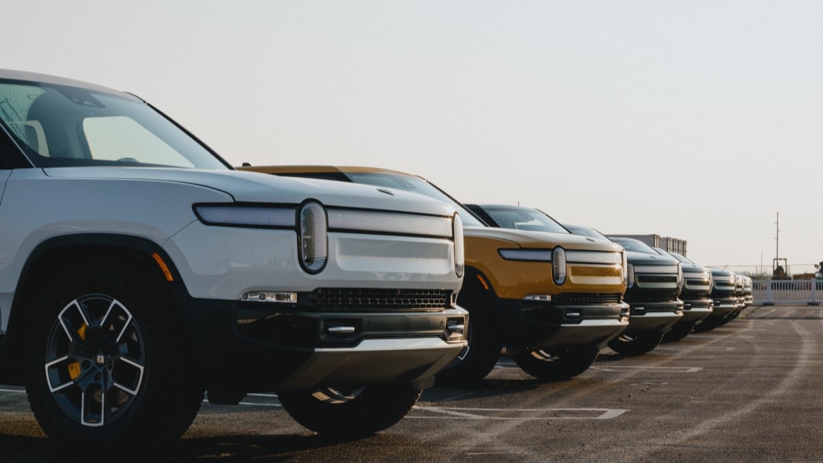 A line of Rivian vehicles parked side-by-side