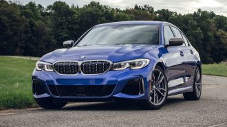 2020 BMW 3 Series in blue with trees in the background.