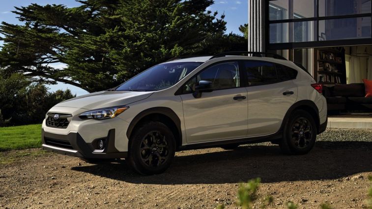2023 Subaru Crosstrek Hybrid parked near a home.