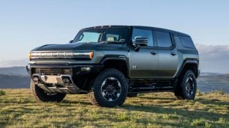 2024 GMC HUMMER EV SUV in Moonshot Green Matte overlooking mountain vista.