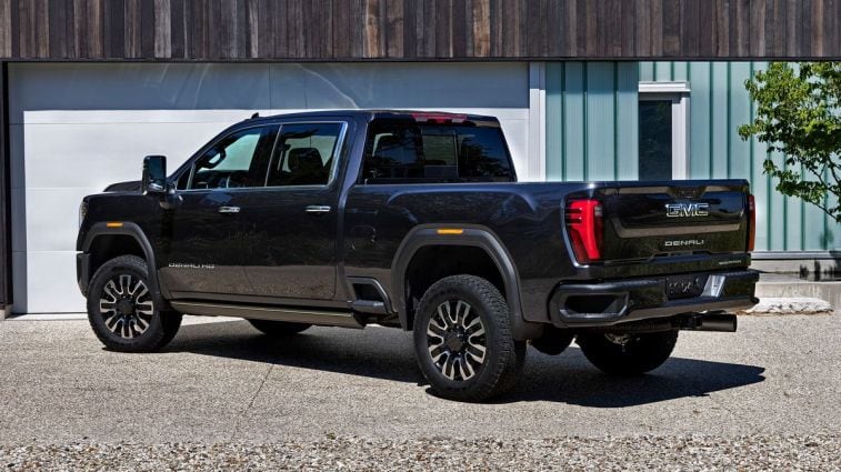 2024 GMC Sierra 2500 HD Denali Ultimate parked near a garage.