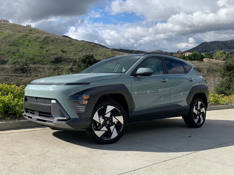 2024 Hyundai Kona Limited with hills and clouds in the background.