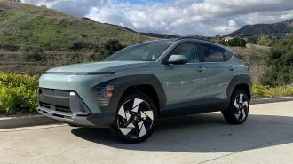 2024 Hyundai Kona Limited with hills and clouds in the background.