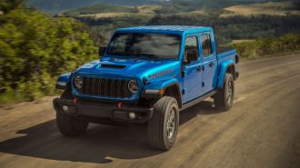 2024 Jeep Gladiator Mojave X driving down a dirt road.