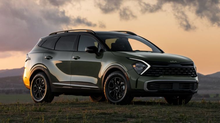 2024 Kia Sportage X-Pro متوقفة على العشب عند غروب الشمس.