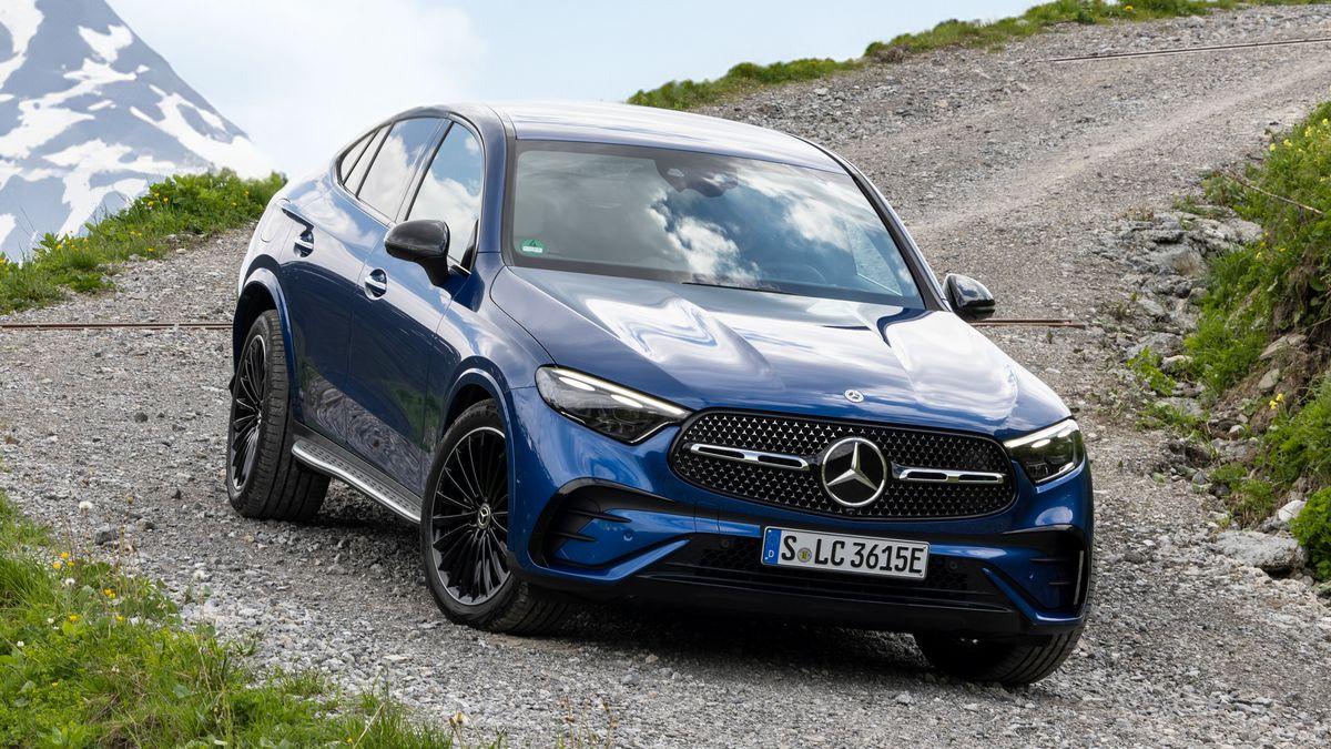 2024 Mercedes-Benz GLC 300 4MATIC Coupe in blue on a gravel road with a snowy mountain in the background.