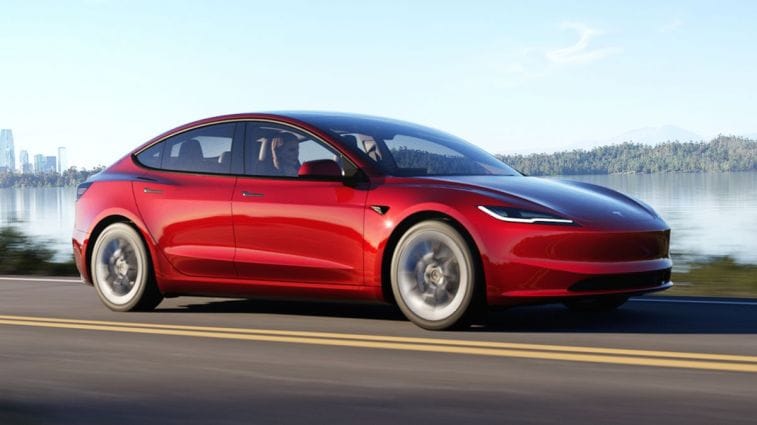 2024 Tesla Model 3 driving down a road.