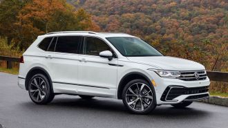 2024 Volkswagen Tiguan in white with fall foliage in the background.
