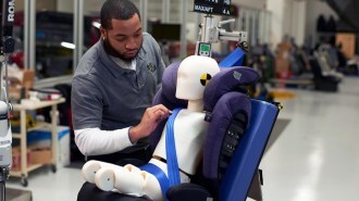 An Insurance Institute for Highway Safety technician inspects a child booster seat