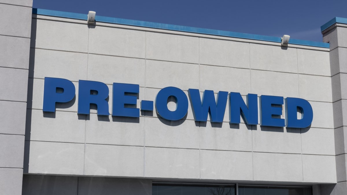 A sign advertising pre-owned cars at a dealership