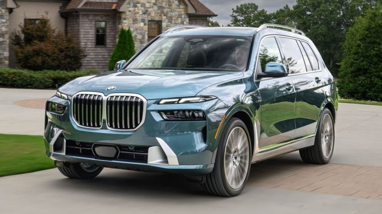 2023 BMW X7 40i in Blue Ridge driving by a nice house.