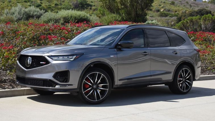 2024 Acura MDX Type S in grey with shrubs in the background.