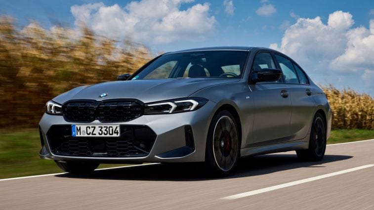 سيارة BMW M340i موديل 2024 باللون الفضي تسير على طريق بجوار حقل ذرة.