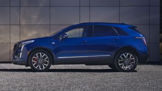 2024 Cadillac XT5 in Opulent Blue Metallic parked on gravel.