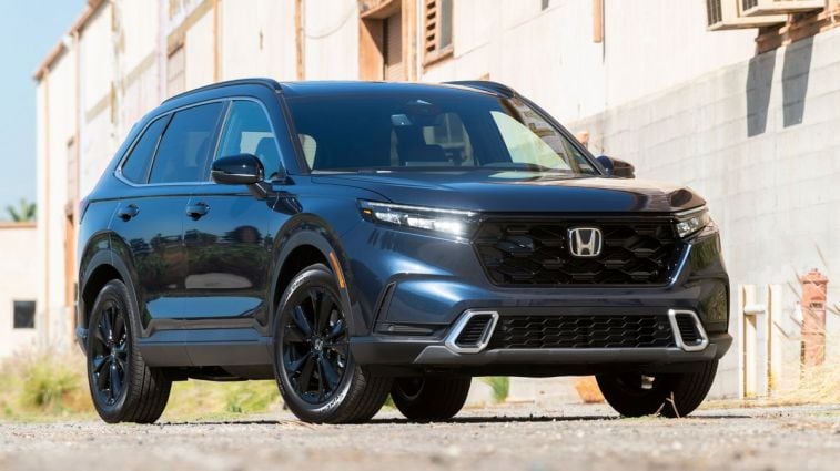2024 Honda CR-V Hybrid next to a warehouse.