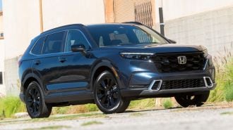 2024 Honda CR-V Hybrid next to a warehouse.