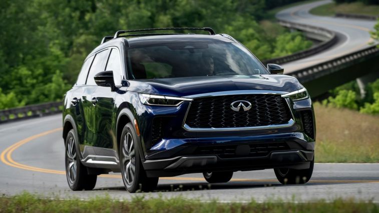 2024 Infiniti QX60 in blue driving on a curvy road.