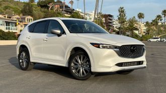 2024 Mazda CX-5 Signature in white in a beach parking lot.