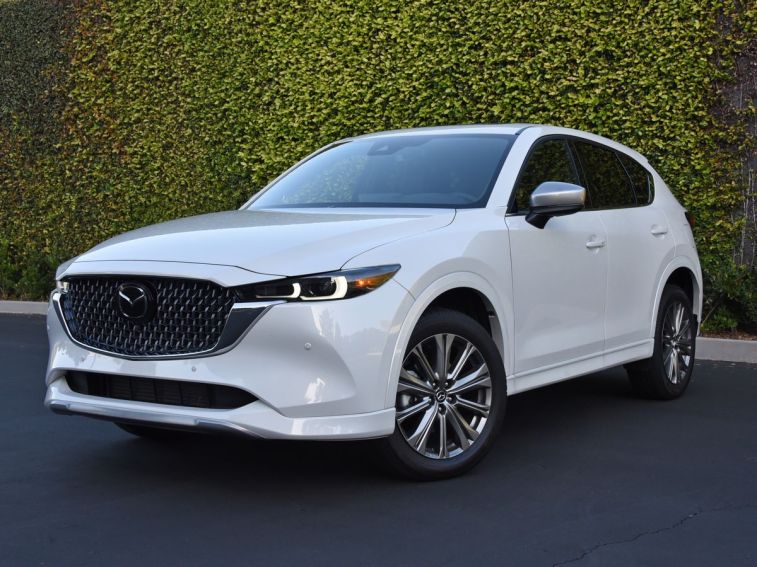 2024 Mazda CX-5 Signature in white with an ivy wall in the background.