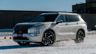 Front view of the 2024 Mitsubishi Outlander PHEV driving on snow