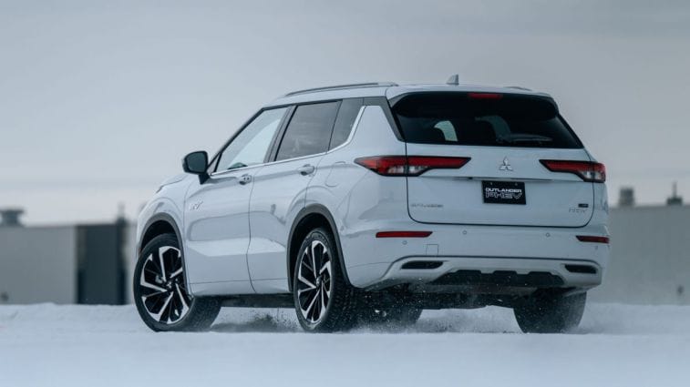 Rear view of the 2024 Mitsubishi Outlander PHEV driving on snow