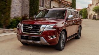 2024 Nissan Armada driving down an old street.