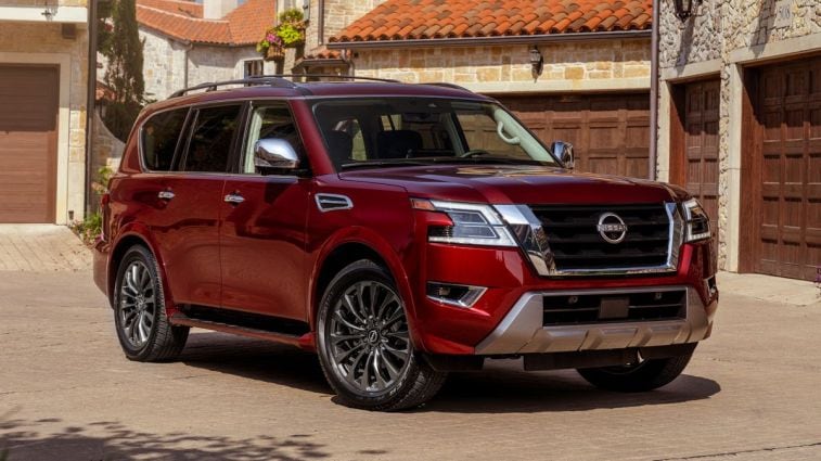 2024 Nissan Armada parked in front of wooden garage doors.