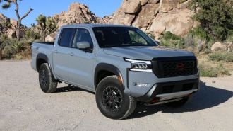 2024 Nissan Frontier Pro-4X in grey with rock formations in the background.