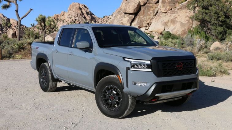 2024 Nissan Frontier Pro-4X in grey with rock formations in the background.