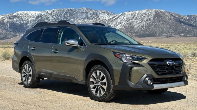 2024 Subaru Outback Touring in green with mountains in the background.