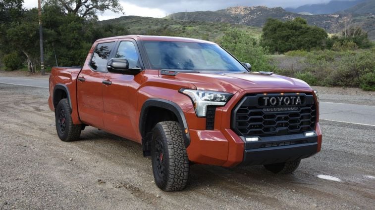 2024 Toyota Tundra TRD Pro parked on dirt with trees in the background.