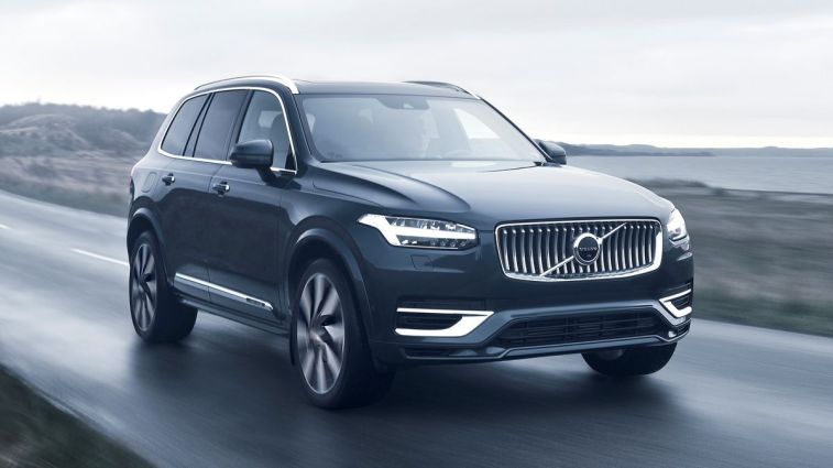 2024 Volvo XC90 Recharge T8 AWD in Denim Blue driving down a road.