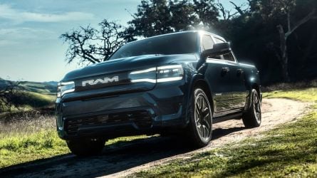 2025 Ram 1500 REV in blue parked a dirt road.