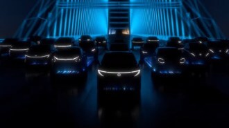 A teaser shot showing cars Nissan plans to launch by 2026, poorly lit.